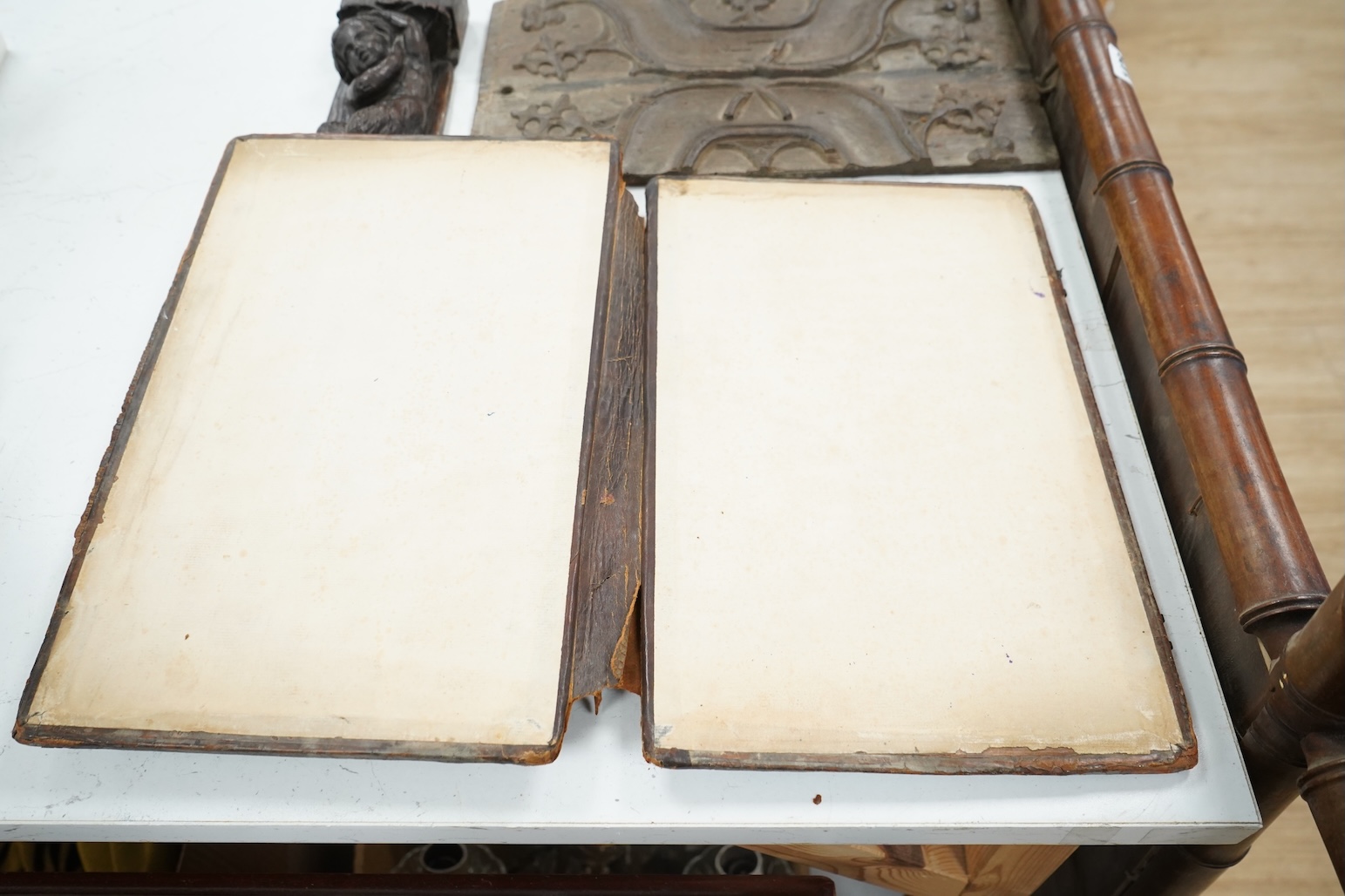 A 19th century leather binding for a book, 35cm high x 33.5cm wide, two carved gothic panels and a carved figure